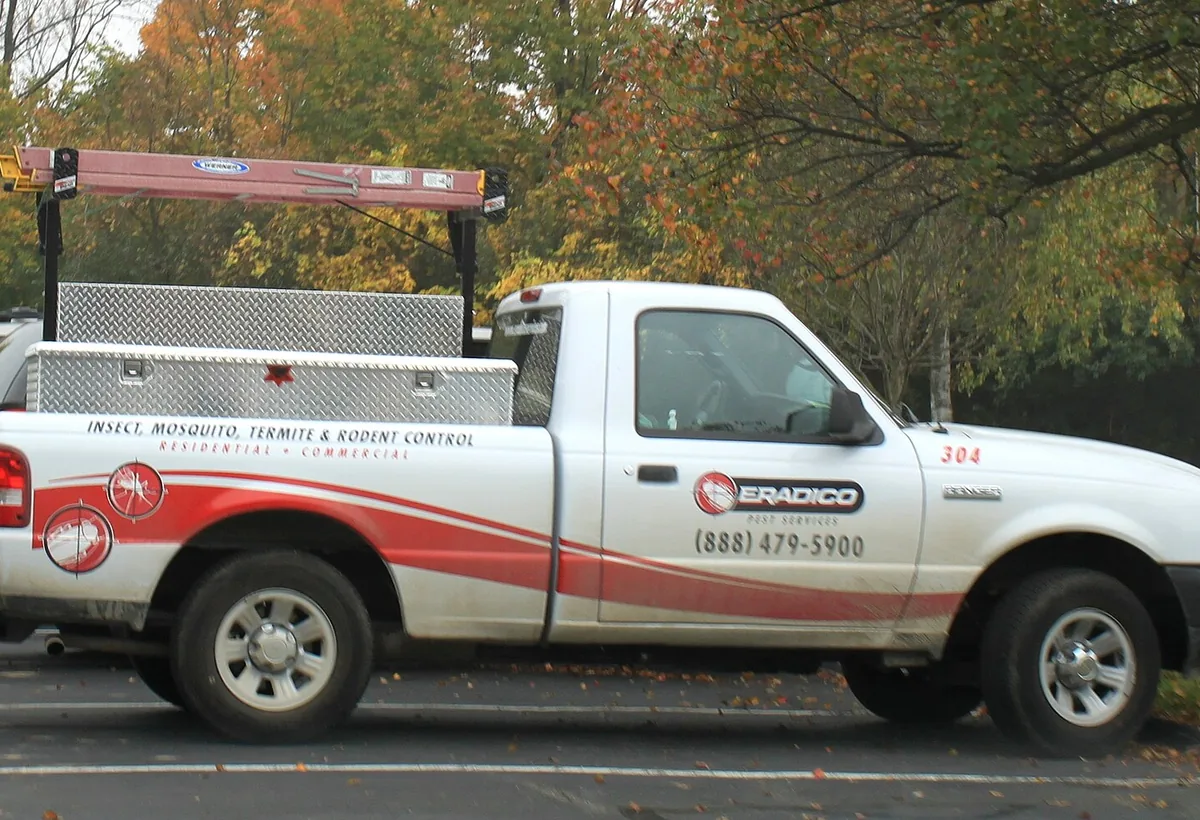 Pest control technician applying outdoor treatment